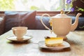 Slice of lemon cheesecake with cup of tea with flowers. Royalty Free Stock Photo