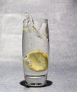 Slice of lemon dropped in glass of water Royalty Free Stock Photo