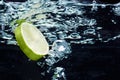 Slice of lime (lemon) falling in water Royalty Free Stock Photo