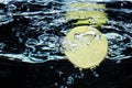 Slice of lime (lemon) falling in water Royalty Free Stock Photo