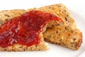 Slice of multi-seed wholegrain bread toasted and buttered with jam.