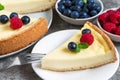 Slice of New York cheesecake with fresh berries and mint with fork on stone background. close up Royalty Free Stock Photo