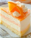 A slice of orange cake on a plate with a fork Royalty Free Stock Photo
