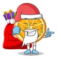 Slice Orange cartoon mascot character in Santa costume with candy