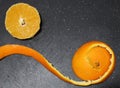 Slice of orange and peel on black background