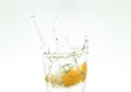 Slice the orange slice in a glass of water and make a spray on a white background. water spray in the air. a slice of citrus drops Royalty Free Stock Photo