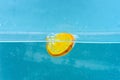 Slice of orange under water with transparent bubbles and water drops splashes. Cocktail making concept. Orange in pure Royalty Free Stock Photo