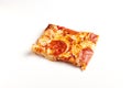 Square piece of Pepperoni Pizza on white table. Royalty Free Stock Photo