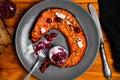 Slice of oven-baked pumpkin with feta cheese, cranberries and sunflower seeds on a plate with cranberry and cream sauce.