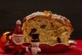 A slice of panettone next to Christmas ornaments