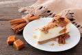 Slice of pecan caramel cheesecake on a wood background
