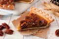 Slice of pecan pie, close up scene with a white wood background Royalty Free Stock Photo