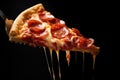 Slice Of Pepperoni Pizza Lifted By Fork On Black Background Royalty Free Stock Photo