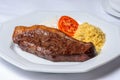Slice of picanha meat barbecue on plate with rice, flour and tomato. Brazilian gastronomy