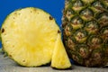 Slice of pineapple and whole pineapple on blue background close-up. Royalty Free Stock Photo