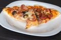 Slice of pizza with bacon cheese and olives lies on a plate Royalty Free Stock Photo