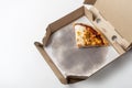 A slice of pizza in a cardboard box on a white background. top view, copy space Royalty Free Stock Photo