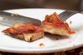 A slice of pizza on a plate close-up. Eat pizza with a knife and fork. Use cutlery at lunch. Juicy slice of pizza. Italian cuisine Royalty Free Stock Photo