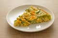 Slice of pizza: Toppings are zucchini, corn kernels and mozzarella cheese. Wooden table. Detail of meal, closeup, selective focus. Royalty Free Stock Photo