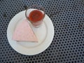 Slice of plain cheesecake with cranberry sauce on white plate decorated