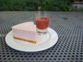 Slice of plain cheesecake with cranberry sauce on white plate decorated