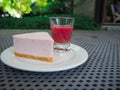 Slice of plain cheesecake with cranberry sauce on white plate decorated