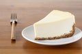 Slice of plain New York Cheesecake on wooden table