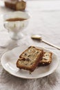 Slice of Pound Loaf Cake with raisins on white porcelain plate and cup of tea Royalty Free Stock Photo