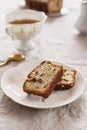 Slice of Pound Loaf Cake with raisins on white porcelain plate and cup of tea Royalty Free Stock Photo