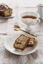 Slice of Pound Loaf Cake with raisins on white porcelain plate and cup of tea Royalty Free Stock Photo