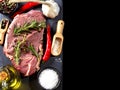 Slice of raw beef steak with spice on wooden spoon ,with rosemary on dark background Royalty Free Stock Photo