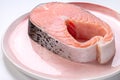 A slice of raw salmon steak on a plate Royalty Free Stock Photo