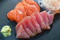 Slice raw tuna and salmon fish sashimi Japanese food with radish on plate dipping shoyu or soybean sauce couple wasabi