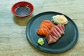 Slice raw tuna and salmon fish sashimi Japanese food with radish on plate dipping shoyu or soybean sauce couple wasabi