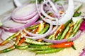 Slice of red onion, red and green chili Hand holding slice of red onion,knife,red and green chili peppers selective focus