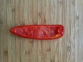 Slice of red pepper onside of a wooden shelf Royalty Free Stock Photo