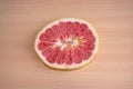 Slice of red pomelo citrus on a wooden background Royalty Free Stock Photo