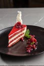 Slice of red velvet cake with raspberries on white plate on the table Royalty Free Stock Photo