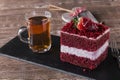 Slice of red velvet cake with white frosting is garnished with strawberries close up Royalty Free Stock Photo