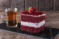 Slice of red velvet cake with white frosting is garnished with strawberries close up Royalty Free Stock Photo