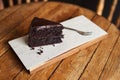 Slice of rich chocolate cake sitting on a cafe table