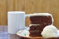 A slice of rich moist 3 layer chocolate cake on a plate Royalty Free Stock Photo