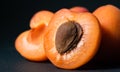 slice of ripe apricot with a seed on a dark background, close-up