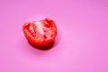 Slice of rotten red tomato vegetable   on a magenta background Royalty Free Stock Photo