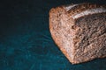 Slice of rustic natural yeast-free bread with flax, poppy seeds, sesame seeds, millet, pumpkin and sunflower seeds, on a black Royalty Free Stock Photo