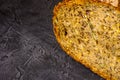 Slice of rustic natural yeast-free bread with flax, poppy seeds, sesame seeds, millet, pumpkin and sunflower seeds, on a black Royalty Free Stock Photo