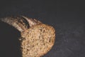 Slice of rustic natural yeast-free bread with flax, poppy seeds, sesame seeds, millet, pumpkin and sunflower seeds, on a black Royalty Free Stock Photo