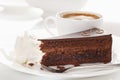 Slice of Sacher cake in plate with coffee