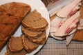 Slice of salted pork and some pieces of round bread and a half-loaf.