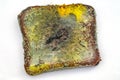 Slice of stale rye bread with mold. Spoiled bread with colored mold. White background. Top view. Royalty Free Stock Photo